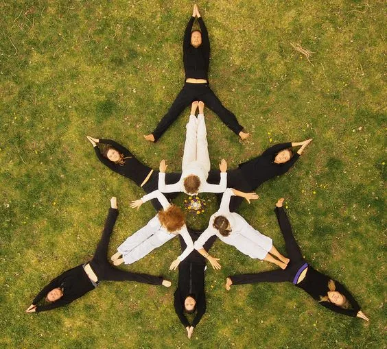 Nhiều người cùng đứng tạo hình yoga nhóm thể hiện tinh thần đồng đội