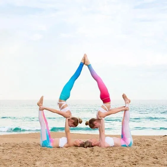 Tư thế yoga nhóm 3 người phức tạp với sự kết hợp của thăng bằng tay và gập lưng