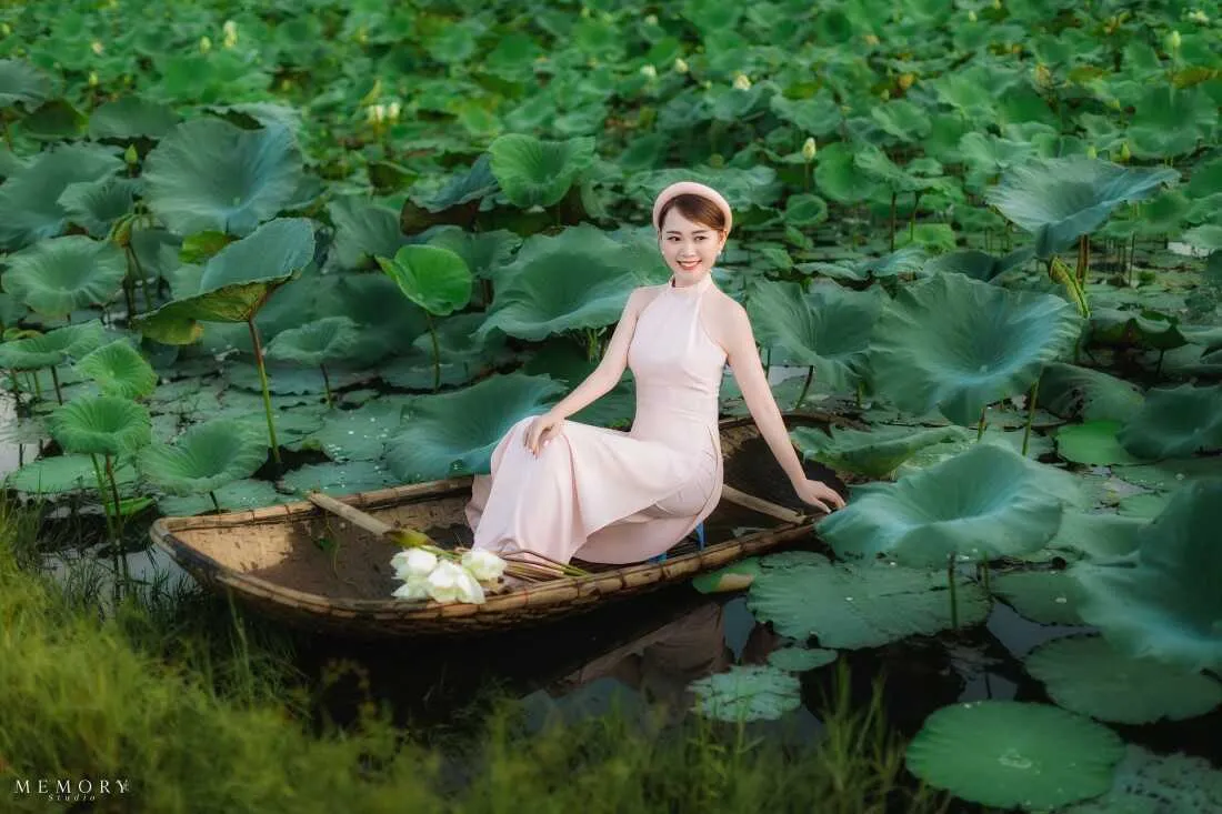 Thiếu nữ ngồi trên thuyền ngắm sen