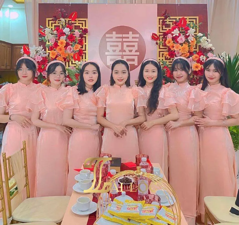 Áo dài bê tráp màu hồng pastel với họa tiết nhẹ nhàng