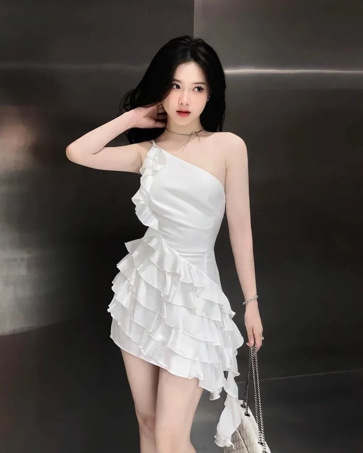 Cô gái xinh đẹp mặc váy trắng ngắn che mặt, tạo dáng bí ẩn quyến rũ