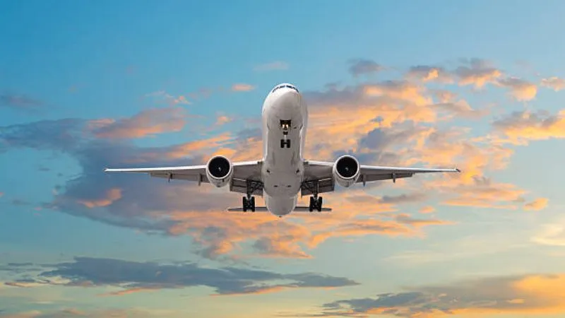 Máy bay phản lực cất cánh vào buổi sáng sớm, ánh nắng bình minh chiếu vào thân máy bay