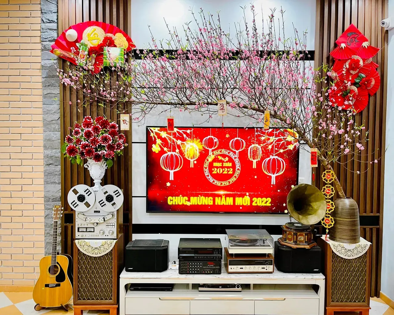 Bình hoa tươi rực rỡ đặt trên kệ TV, mang sắc xuân vào không gian phòng khách ngày Tết