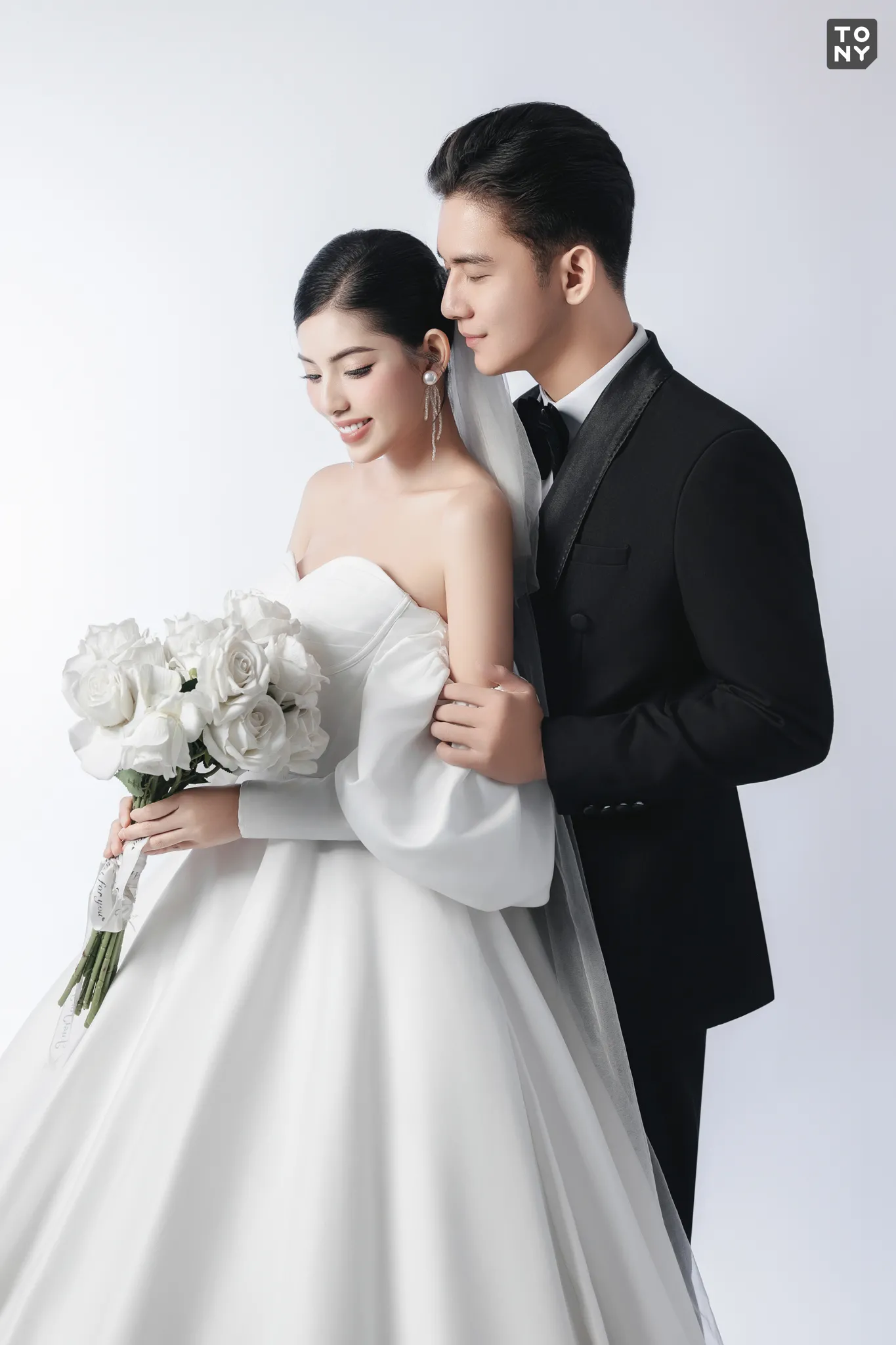 Một cặp đôi đang tạo dáng chụp ảnh cưới trong studio