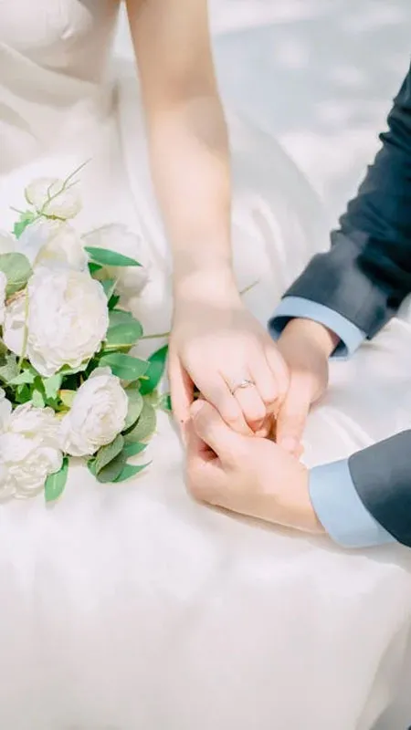 Nhẫn cưới trên tay nắm lấy nhau, phông nền ngoài trời