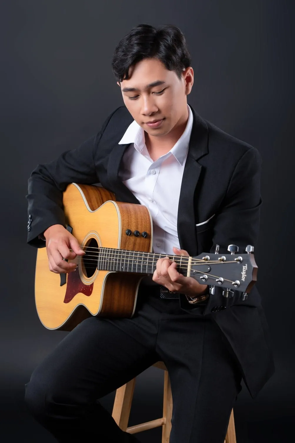 Ảnh chân dung nam nghệ sĩ bên đàn guitar