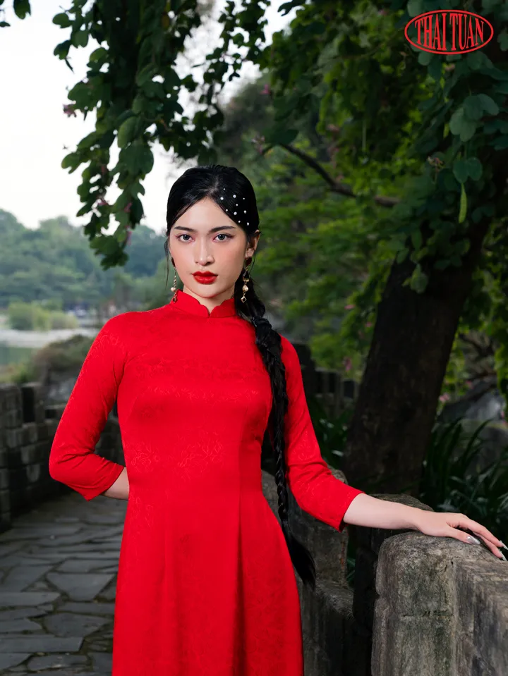 Người mẫu mặc áo dài gấm màu đỏ truyền thống.