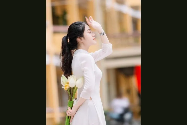 Nữ sinh áo dài trắng tạo dáng góc nghiêng với nụ cười mỉm