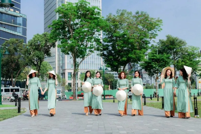 Nữ sinh áo dài trắng cầm chùm bóng bay, tạo dáng nhí nhảnh