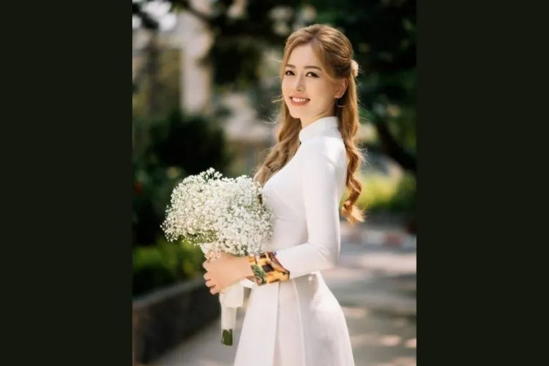 Nữ sinh áo dài trắng chụp chính diện với bó hoa sen
