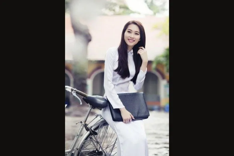 Nữ sinh áo dài trắng tạo dáng với bó hoa và balo