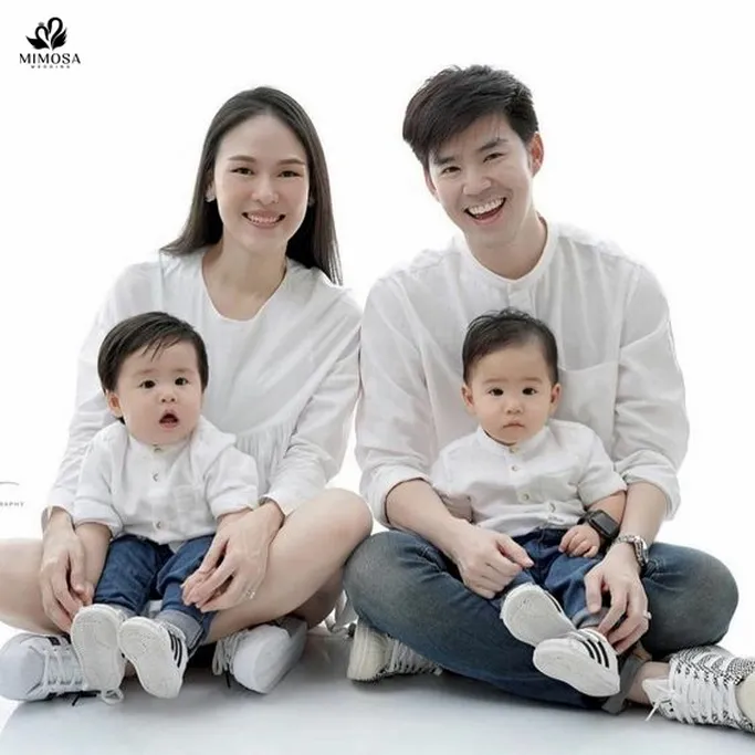 Hai bé sinh đôi ngồi cạnh nhau trong hình gia đình 4 người