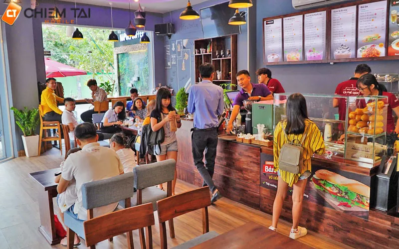Nhóm người ngồi cười đùa và tương tác trong quán cafe, thể hiện không ngại khi chụp ảnh nơi đông người