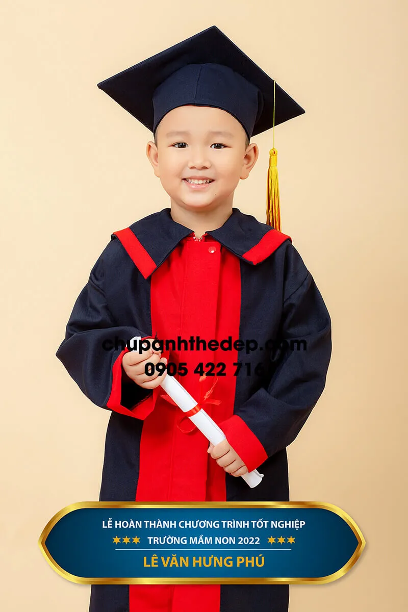 Bé trai cười tươi trong bộ đồ cử nhân chụp kỷ yếu mầm non