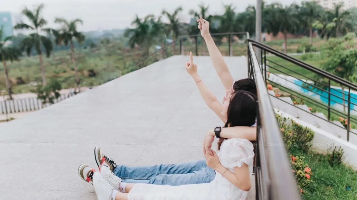 Ảnh cặp đôi ngồi cạnh nhau tạo dáng giấu mặt