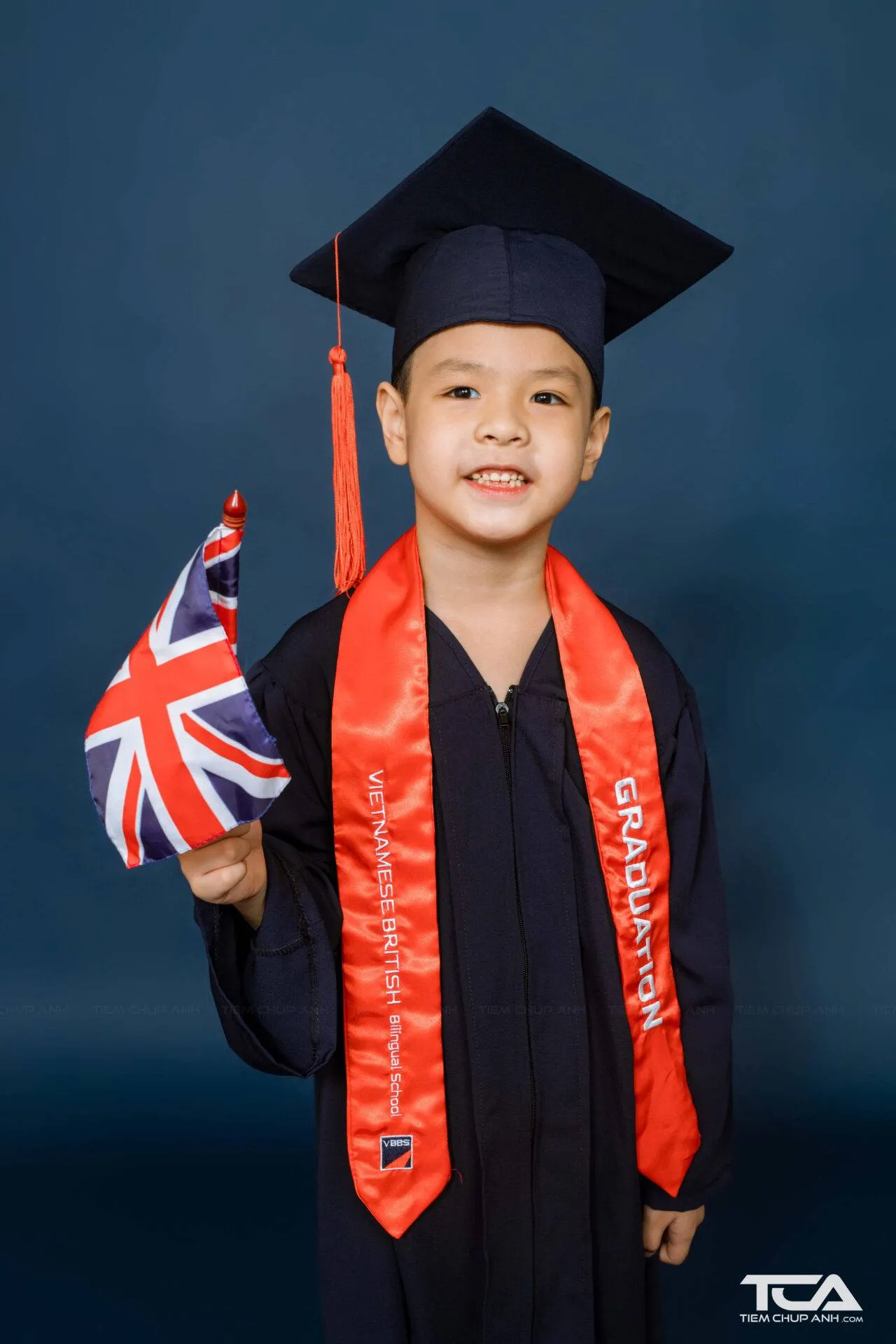 Bé trai trong trang phục bác sĩ chụp ảnh kỷ yếu