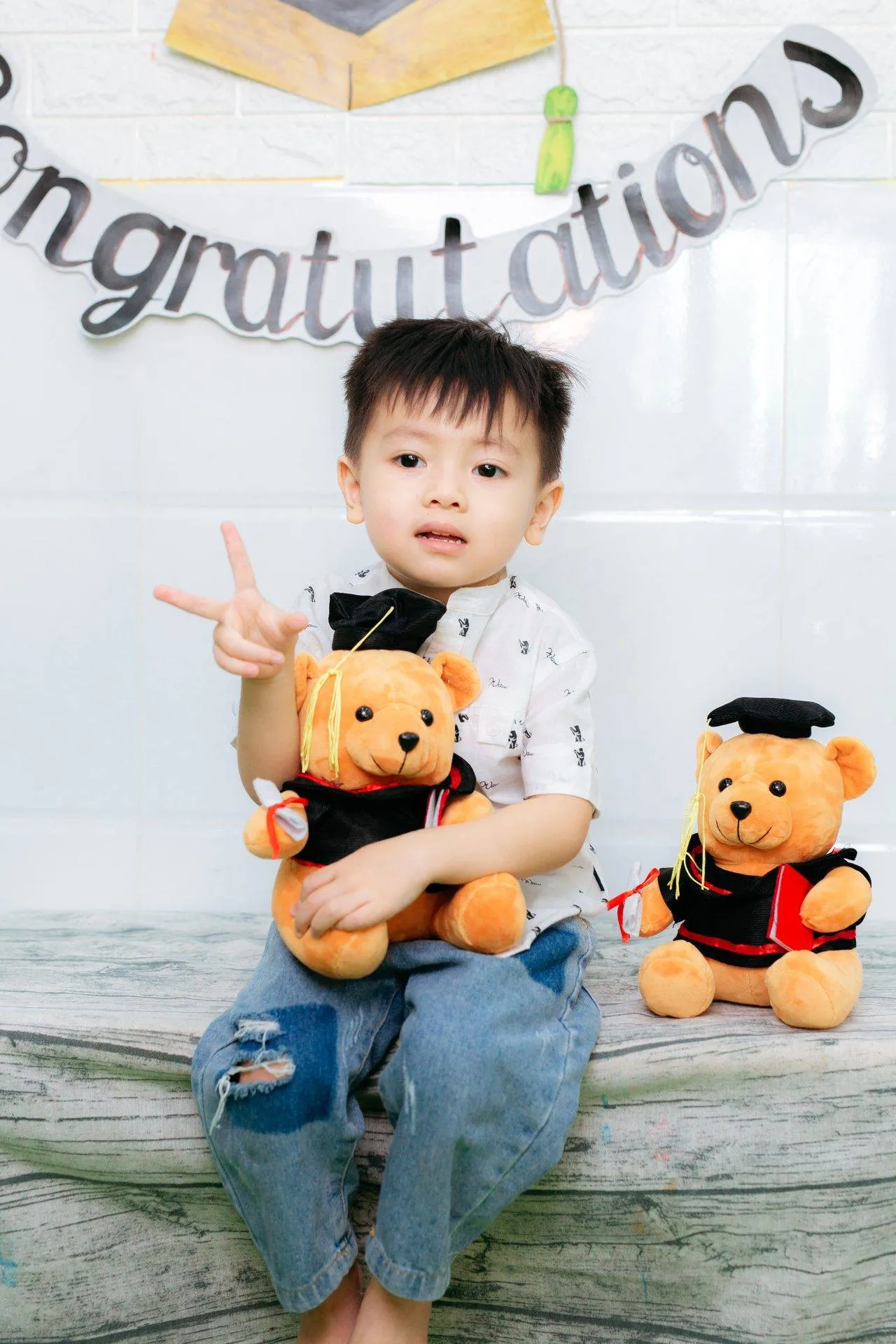 Bé trai chỉ tay tạo dáng chụp hình kỷ yếu