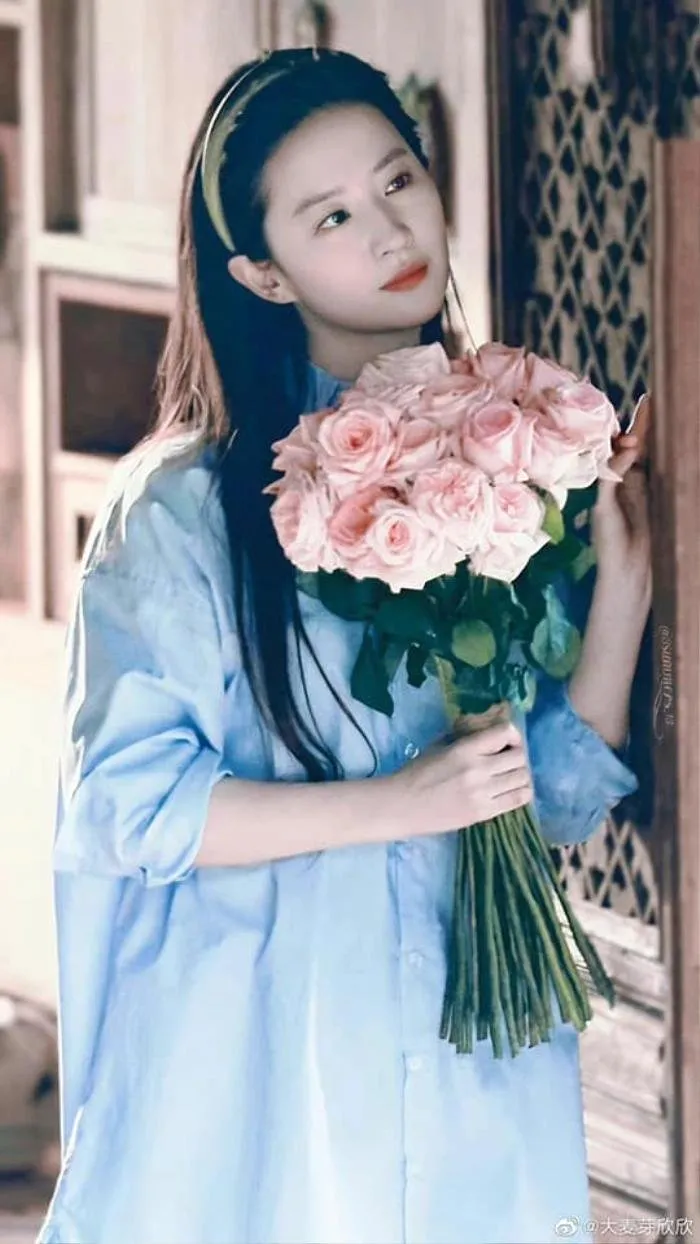 Bó hoa hồng đỏ cầm tay, tô điểm nét duyên dáng cho tà áo dài kỷ yếu