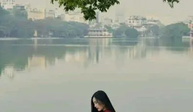Tạo dáng ngồi cạnh bồn hoa, cúi nhìn hoa