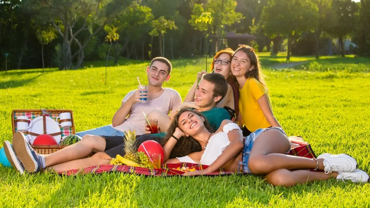 Nhóm bạn ngồi quây quần chụp ảnh tập thể trong buổi dã ngoại.